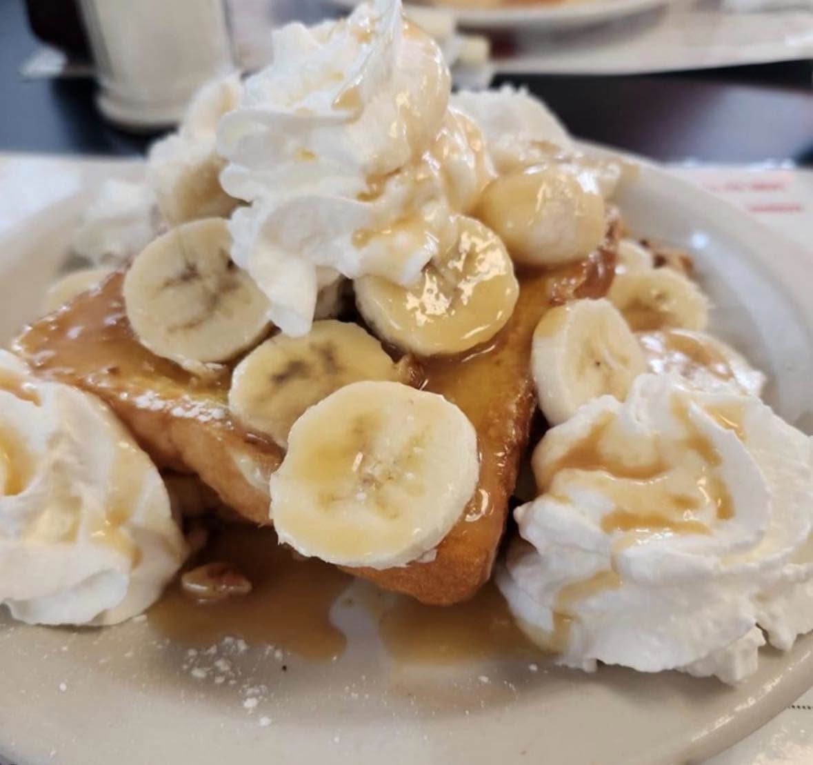 Bananas foster french toast piled with whipped cream
